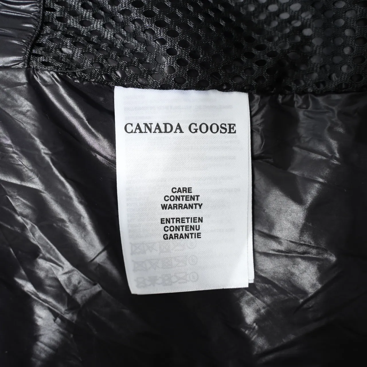 P940 Canada Goose Lawrence Down Jacket The Lawrence Down Jacket provides essential protection for everyday adventures and is made from sustainable Enduraluxe fabric with a durable soft touch. It features a quilted body, an adjustable down hood and a longer hem. Adjustable, down-filled, communicated hood. Two-way center front zipper increases range of motion and ventilation. The chin-protecting suede knit stand-up collar is soft and extra-comfortable. Inset rib-knit cuffs for added comfort and locked in heat. CORDURAD piping at the cuffs hem and reflective double-stripe grip tape at the back. Internal shoulder strap Color: black with red label black with black label azure blue Size: XS-2XL